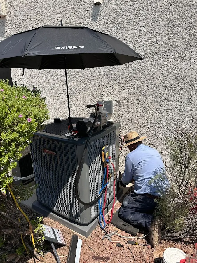 HVAC technician performing outdoor AC maintenance in Urbandale